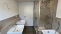 Helles Badezimmer mit Doppelwaschbecken, Badewanne und Dusche in Neupotz-Hardtwald.