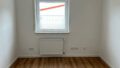 Innenraum einer Erdgeschosswohnung in Neupotz-Hardtwald, mit weiß gestrichenen Wänden, Holzfußboden.
