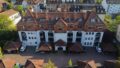 Moderne Mehrfamilienhaus mit roten Ziegeldächern und Loggien in urbaner Lage.