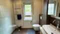 Moderne Badezimmer mit Dusche, WC und Waschtisch in stilvoller Wohnung.