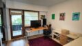 Gemütliches Arbeitszimmer mit Schreibtisch, Stuhl und Balkonblick.