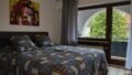 Gemütliches Schlafzimmer mit Blick auf den Nordpark, große Fenster, moderne Einrichtung.